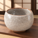 Cuenco gris claro y beige con esmalte craquelado, ambientado en sala de té japonesa.
